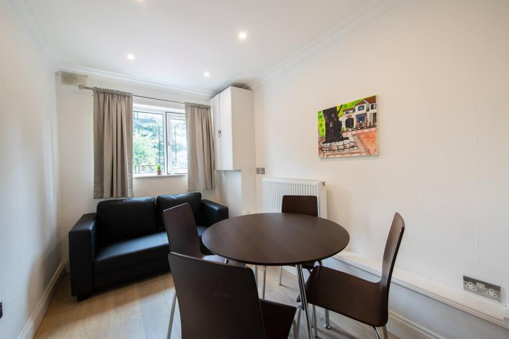 un soggiorno con tavolo e divano di Cozy 2-Bedroom Flat in Battersea a Londra