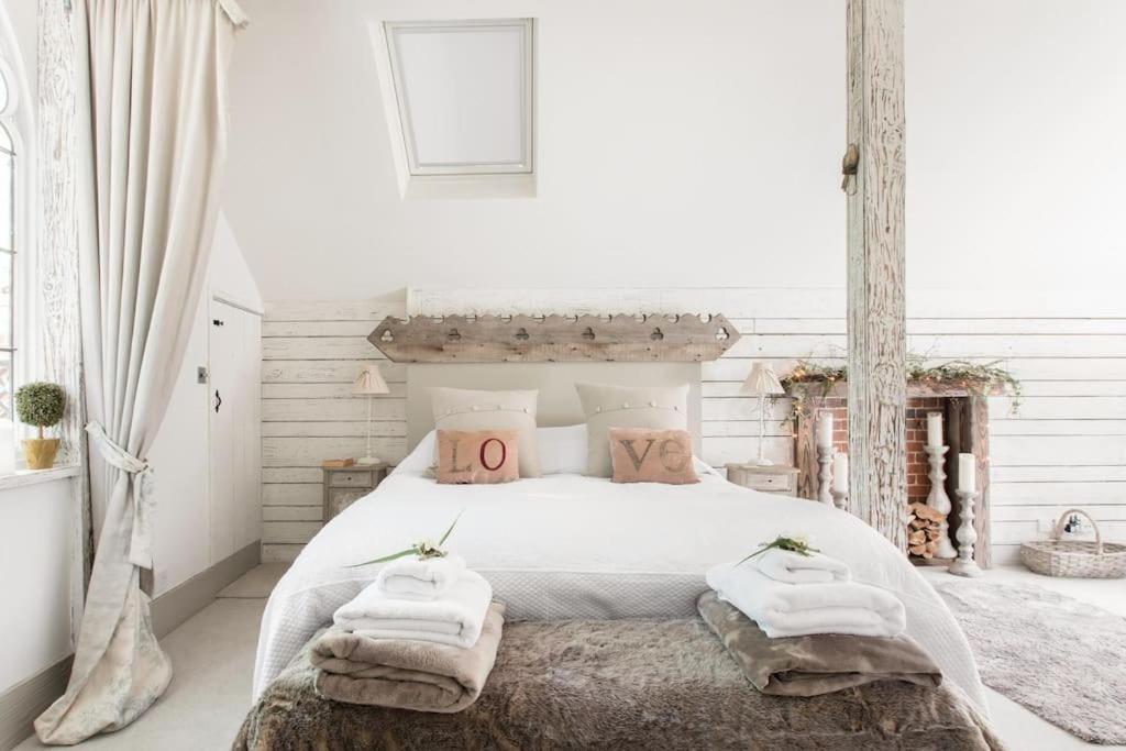 a bedroom with a white bed with towels on it at Magical and Romantic Countryside Getaway Near Windsor Castle in Old Windsor