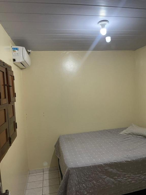 1 dormitorio con 1 cama y una luz en el techo en Casa Oceano, en Marechal Deodoro