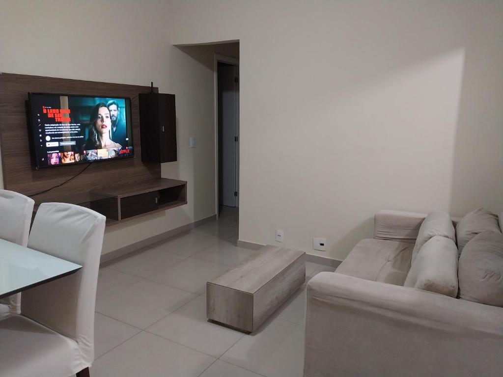 a living room with a couch and a flat screen tv at Apartamento Campos dos Goytacazes de 3 quartos com ar condicionado in Campos dos Goytacazes