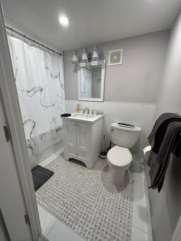 bagno bianco con servizi igienici e lavandino di Two bedroom condo in Upper West Side a New York