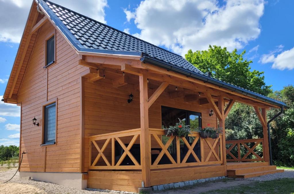 una cabaña de madera con techo de gambrel en Grześny Domek en Zbiczno