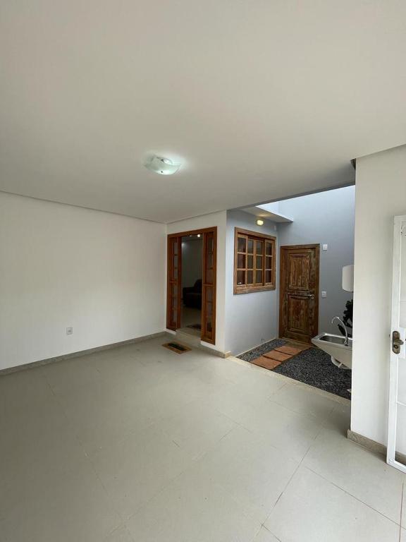 an empty living room with white walls and white floors at Escalada Hospedagem Térreo in Mucugê