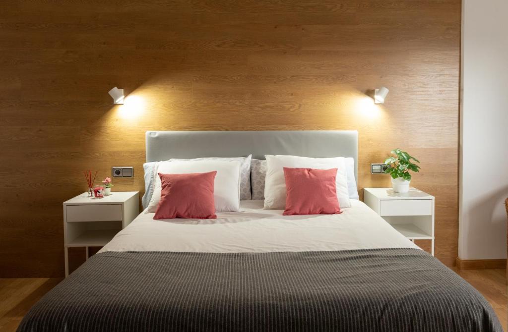 a bedroom with a large bed with red pillows at APARTAMENTO BIENESTAR in A Estrada