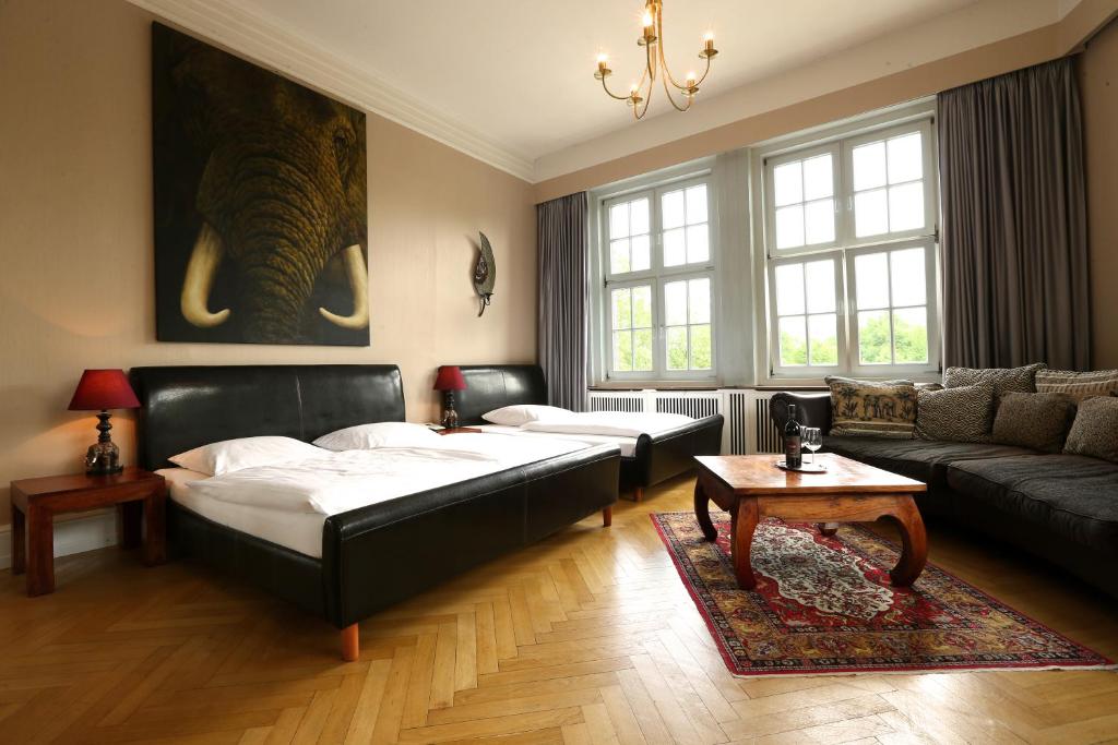 sala de estar con 2 camas y sofá en Hotel Amsterdam, en Hamburgo