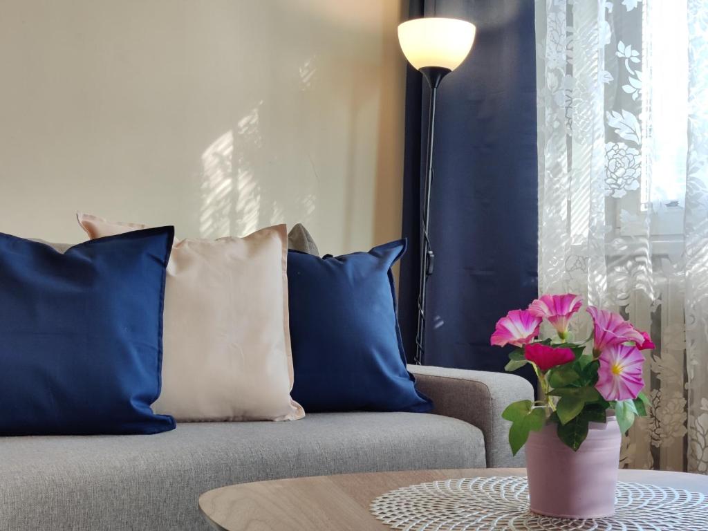 un soggiorno con divano e vaso con fiori di Musninkų apartment near Akropolis a Vilnius