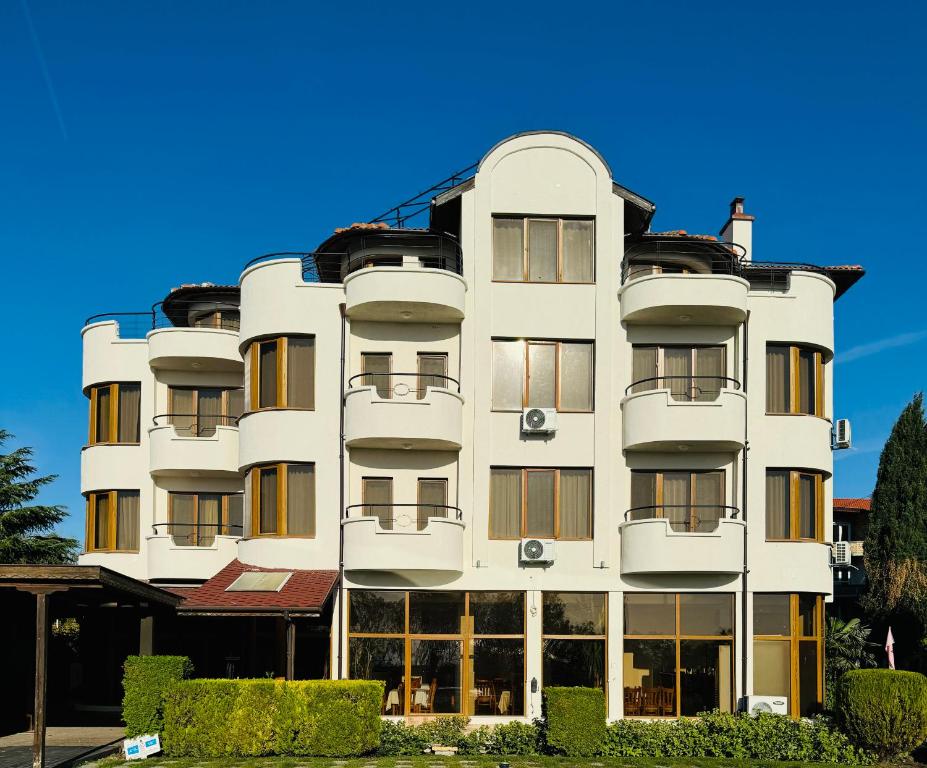 een groot wit gebouw met veel ramen bij Семеен хотел"Свети Георги" in Boergas