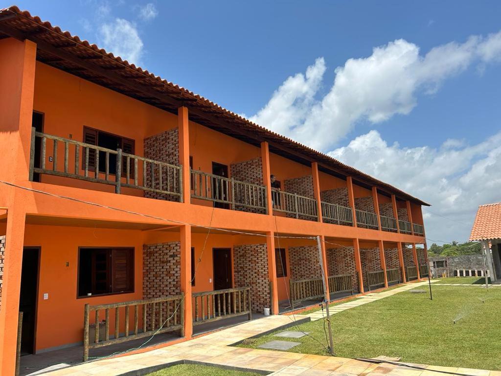um edifício laranja com varandas ao lado em Pousada Lençóis Eco Villa em Santo Amaro