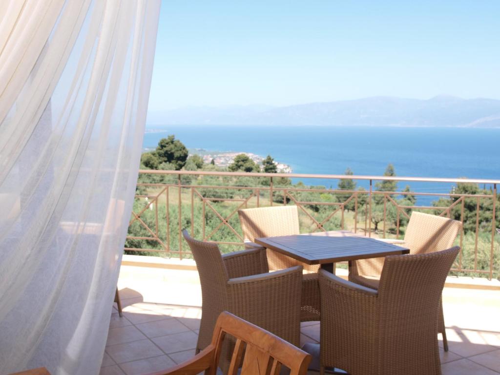einen Tisch und Stühle auf einem Balkon mit Meerblick in der Unterkunft Hotel Theasi in Diakopto
