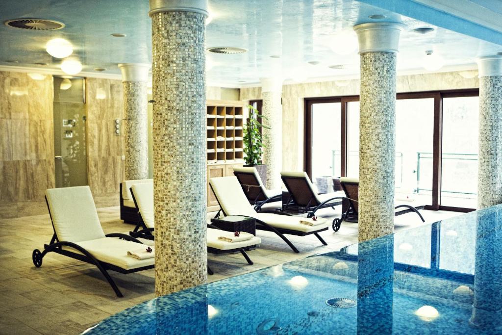 a waiting room with chairs and a swimming pool at Retro Riverside Wellness Resort in Karlovy Vary