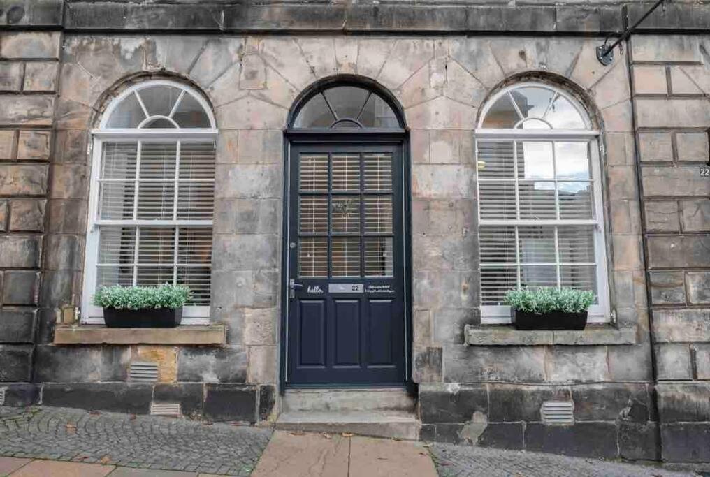 a black door and two windows on a stone building at Broad Street Stirling in Stirling