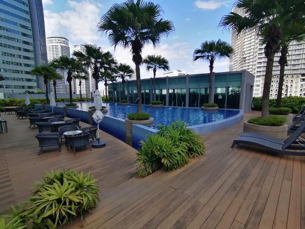 um resort com piscina e palmeiras em Vortex Suites KLCC By Neptune em Kuala Lumpur