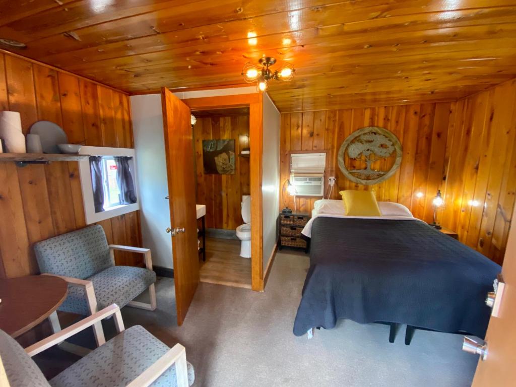 una camera con letto e servizi igienici di Cabin 8 at Horse Creek Resort a Rapid City