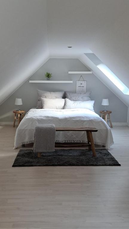 een witte slaapkamer met een groot bed en een tafel bij small Stable - charmantes Häuschen Mitten in Lemgo in Lemgo