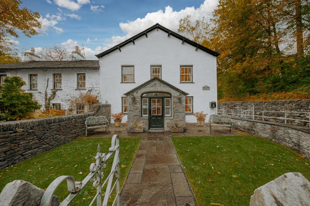 ein weißes Haus mit einer Steinmauer in der Unterkunft Gate House in Coniston