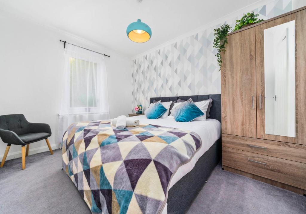 a bedroom with a large bed and a chair at Anderson Apartment by Klass Living Motherwell in Motherwell