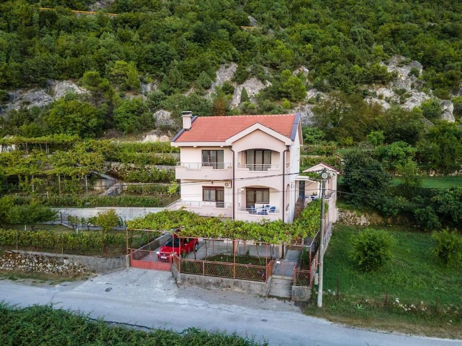 uma casa com um telhado vermelho numa colina em Pavle's Oasis em Virpazar