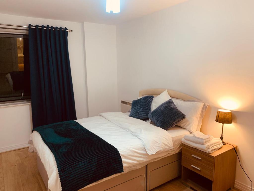een slaapkamer met een bed met een nachtkastje en een raam bij North Acton Flat in Londen