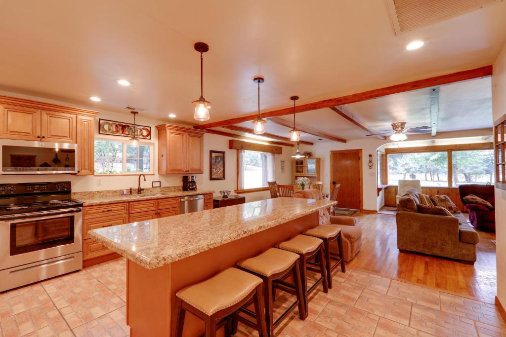a kitchen with a large island with bar stools at Cozy Cabin on 1 Acre in Premier Pine Neighborhood in Pine