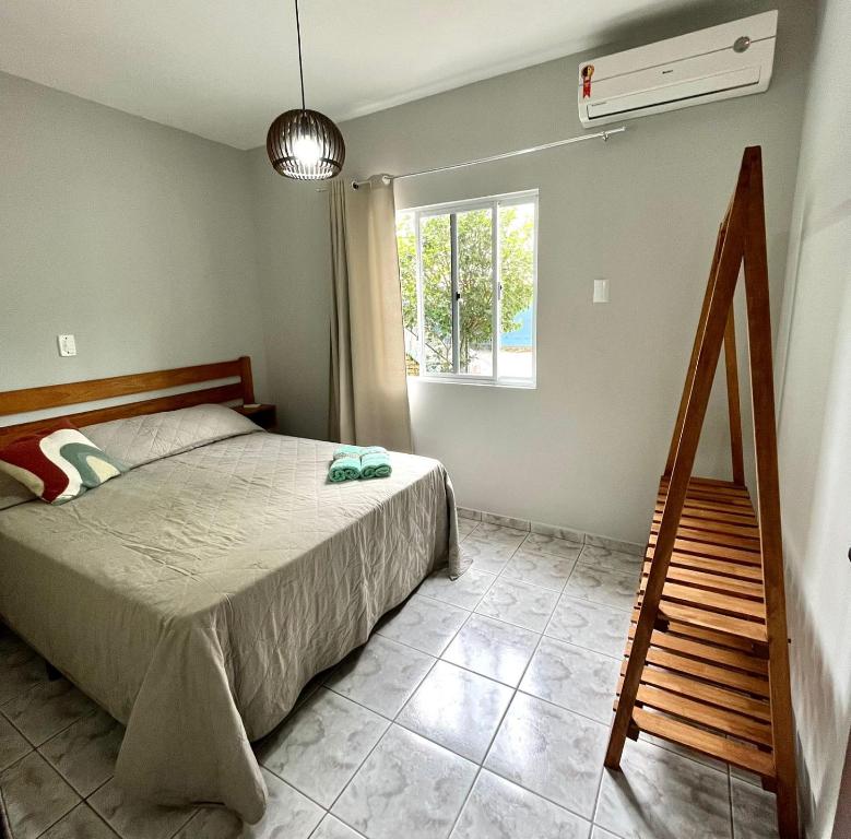 ein Schlafzimmer mit einem Bett, einer Treppe und einem Fenster in der Unterkunft Férias de Verão - Bombinhas in Bombinhas