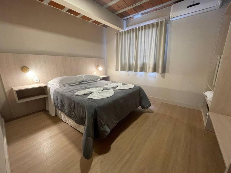 sypialnia z łóżkiem z dwoma ręcznikami w obiekcie Loft 9 entre gramado e canela w mieście Canela