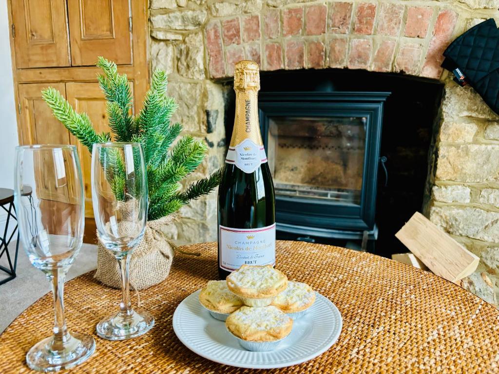 una botella de vino y un plato de galletas y copas de vino en Cotswold Home over 4 floors - perfect for Families Friends Contractors, en Chipping Norton