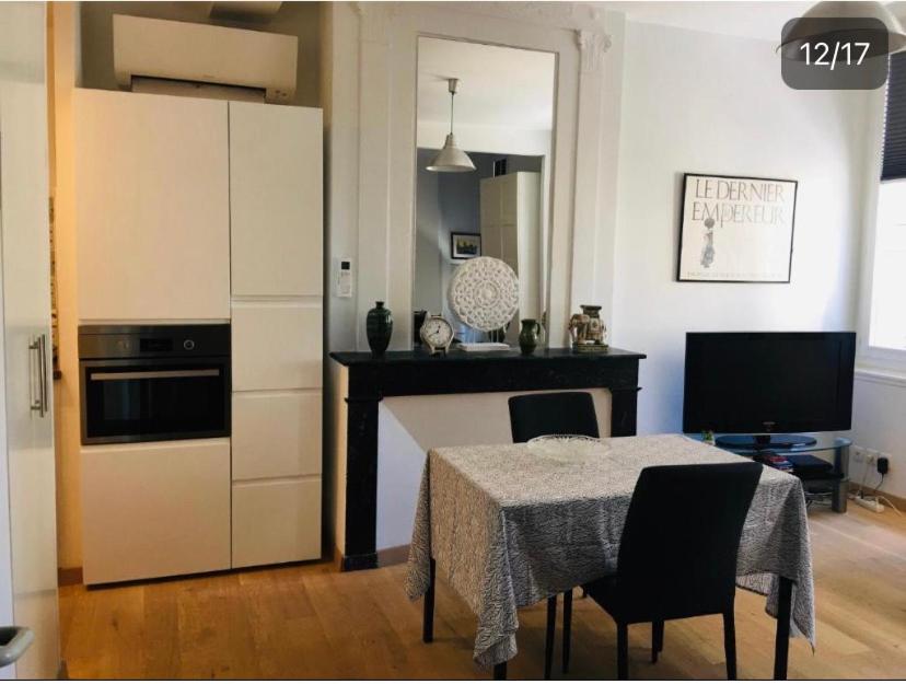 une cuisine avec une table, des chaises et une table, ainsi qu'une cuisine avec un comptoir dans l'établissement Studio Confort centre ville, à Bordeaux