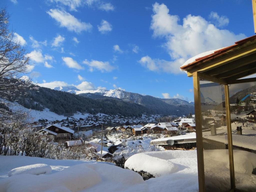 uma cidade coberta de neve com montanhas ao fundo em Chalet Mimi em Morzine