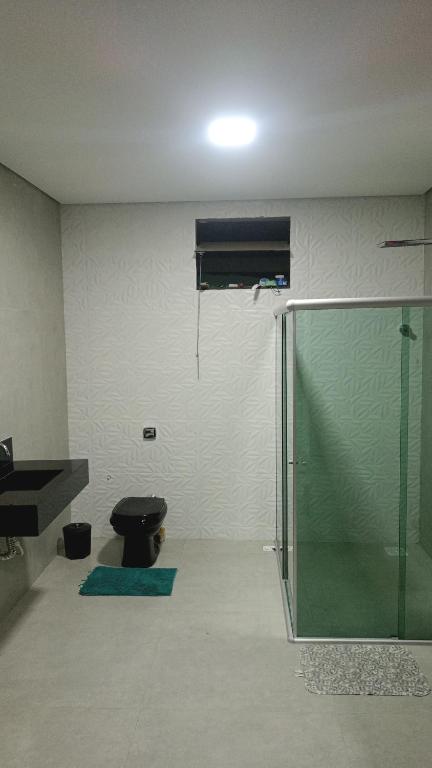 ein Bad mit einer Dusche, einem WC und einem Waschbecken in der Unterkunft Casa de férias in Montes Claros
