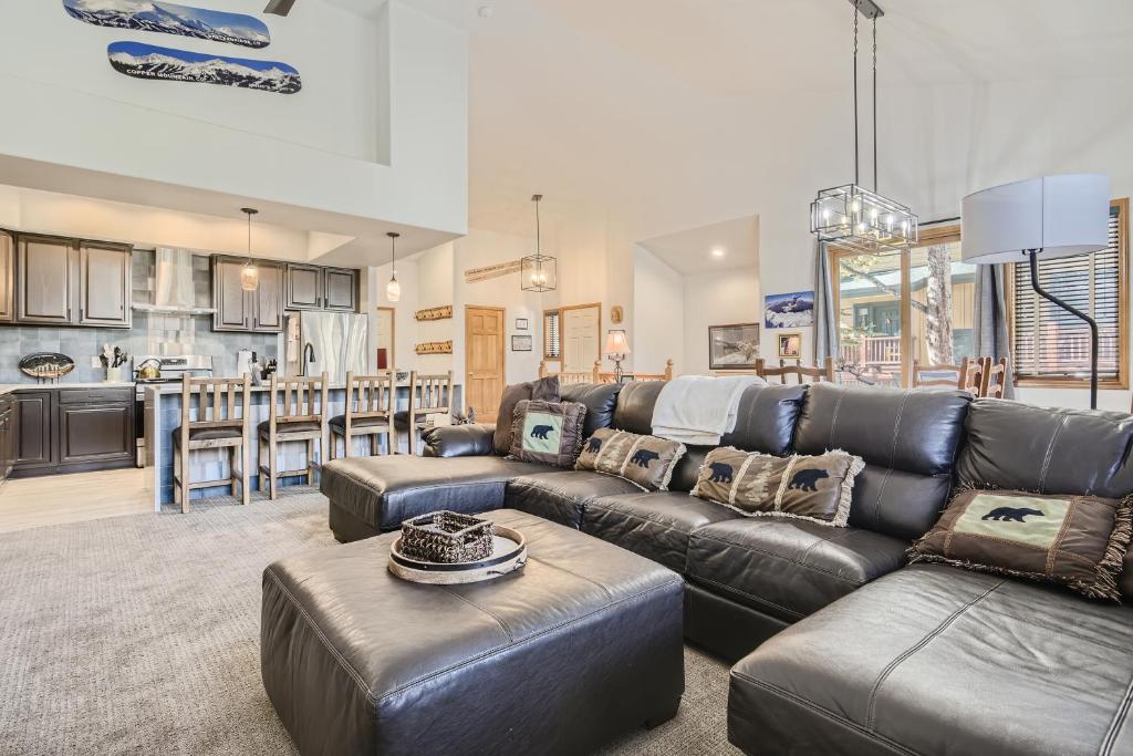 a living room with a leather couch and a kitchen at White Wolf #890 - Great Home with Private Outdoor Hot Tub - Shuttle to Slopes in Breckenridge