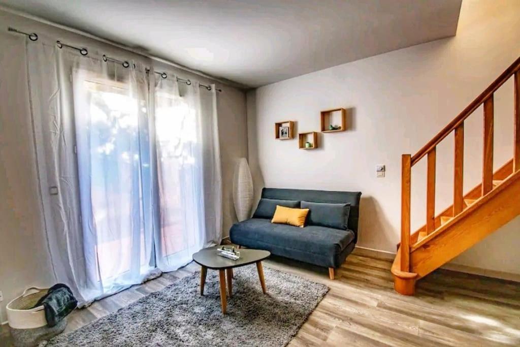 - un salon avec un canapé bleu et un escalier dans l'établissement Les quatre loges n°1, à Aix-en-Provence