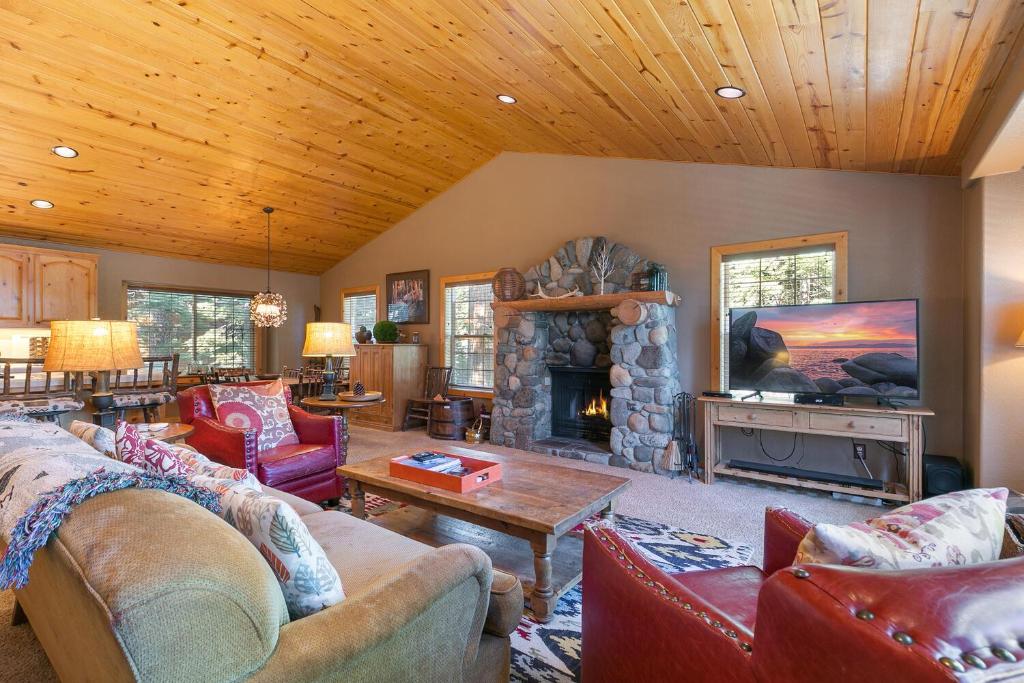 un soggiorno con divani e camino di Alpen Glow by Tahoe Getaways - Private Hot Tub, Close to Northstar a Carnelian Bay