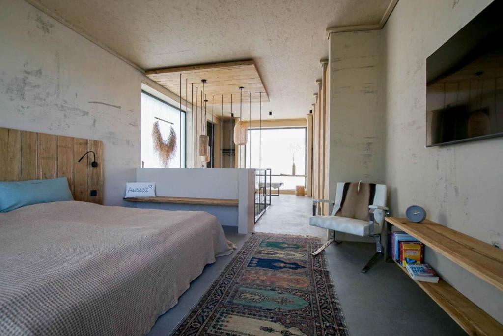 een slaapkamer met een bed, een tafel en een stoel bij Ferienhaus am See in Nordhausen