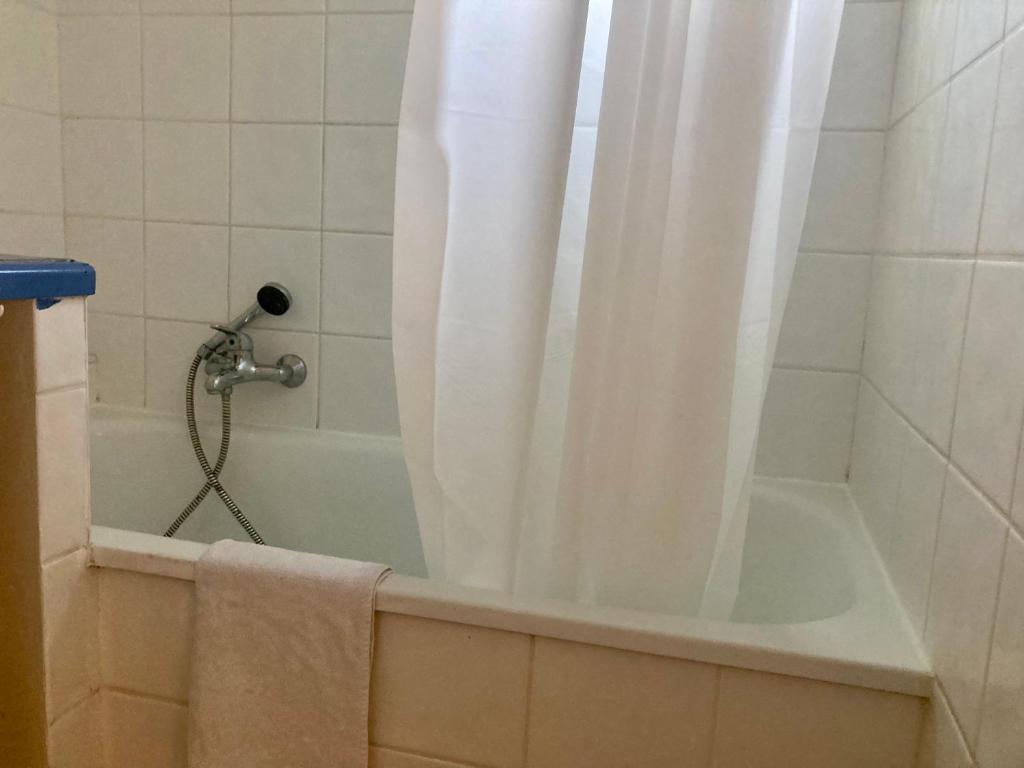 a bath tub with a shower with a shower curtain at Mas de la pie in Saintes-Maries-de-la-Mer