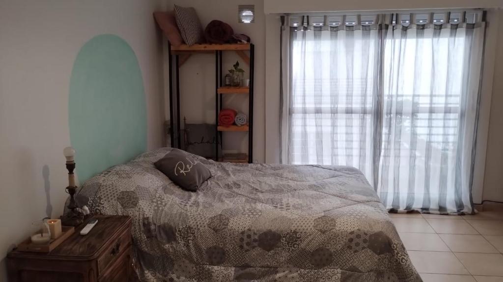 1 dormitorio con cama, mesa y ventana en Departamento en el centro en Rosario