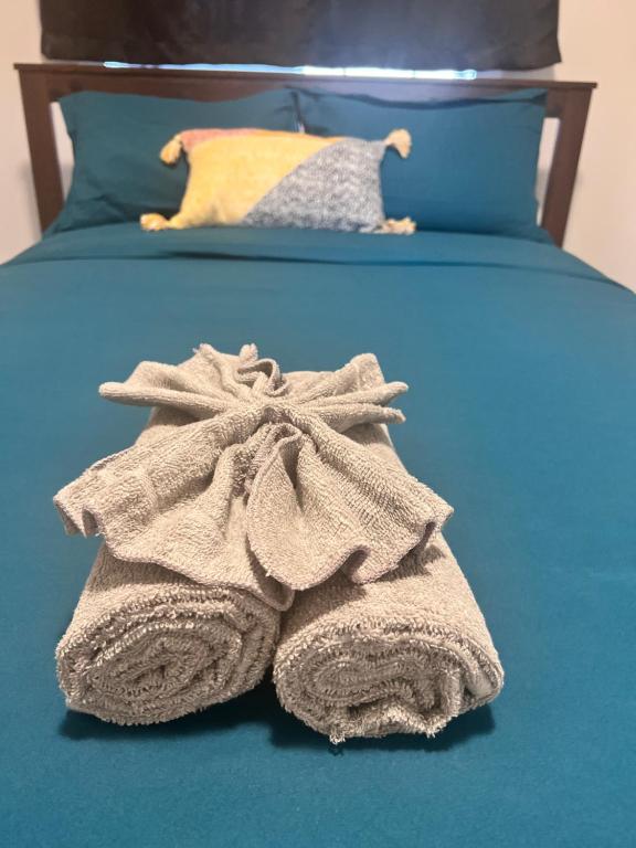 Una cama con un montón de toallas. en Private room in Calgary*Netflix*TV*Wifi*Parking, en Calgary
