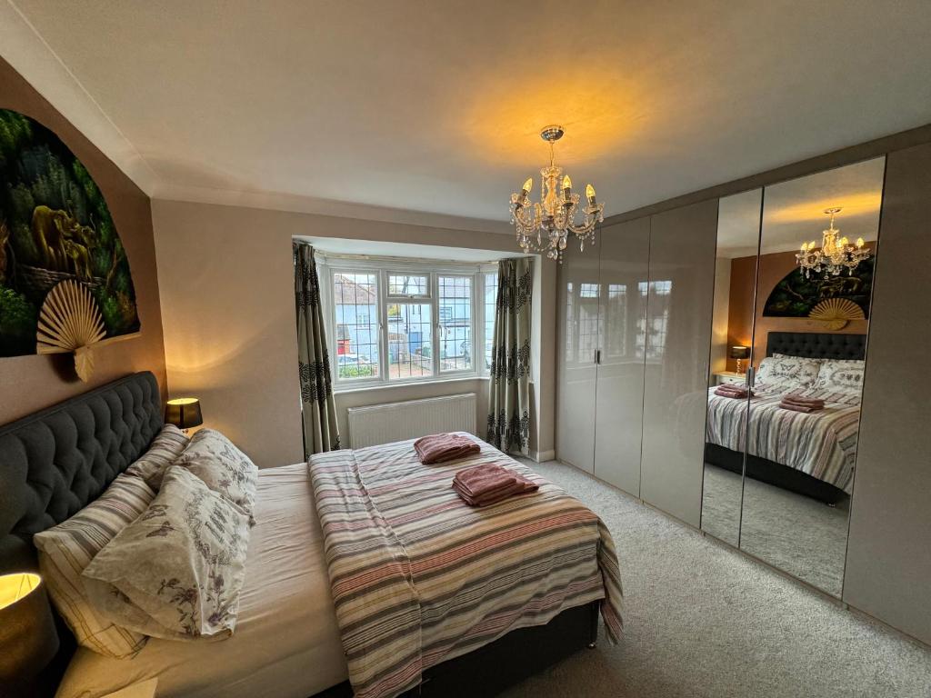 a bedroom with a bed and a mirror at 3 Bedroom House with Garden in London in Cheam