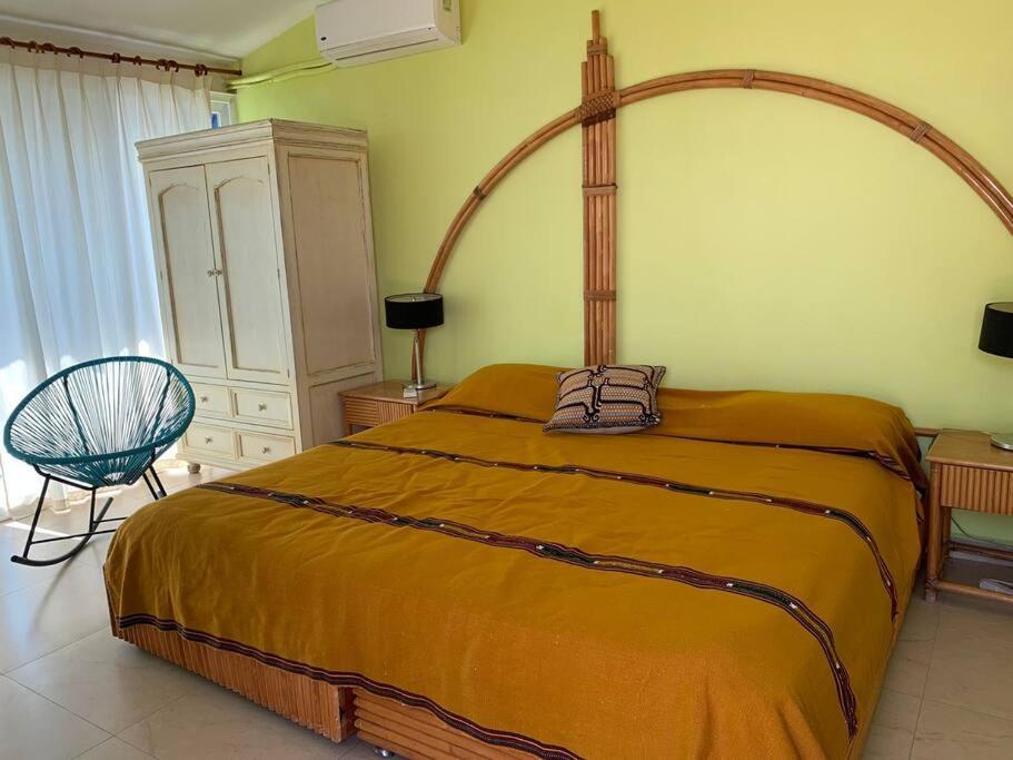 a bedroom with a large bed and a chair at Casa Azul en la orilla del Lago Tequesquitengo in Tequesquitengo