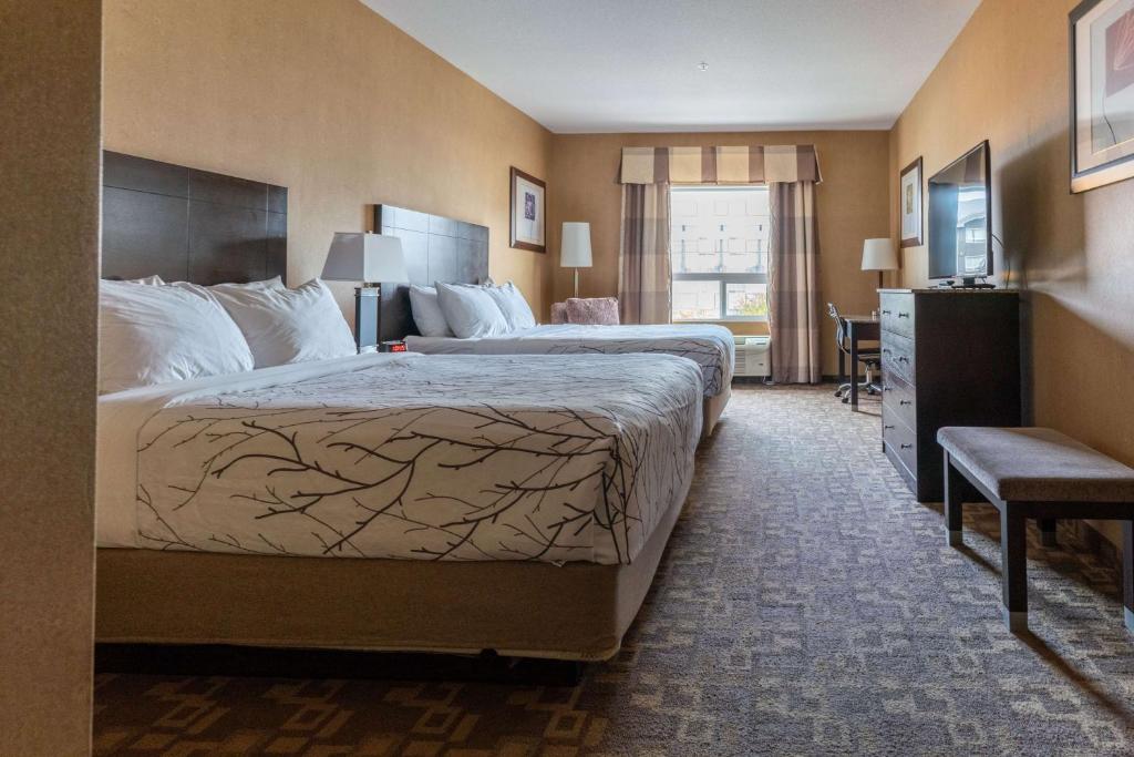 a hotel room with two beds and a desk at Best Western Plus South Edmonton Inn & Suites in Edmonton