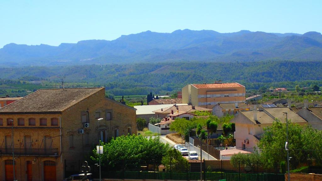 une petite ville avec des bâtiments et des montagnes en arrière-plan dans l'établissement Ebro Escape Luxury Apartment, à Móra d'Ebre