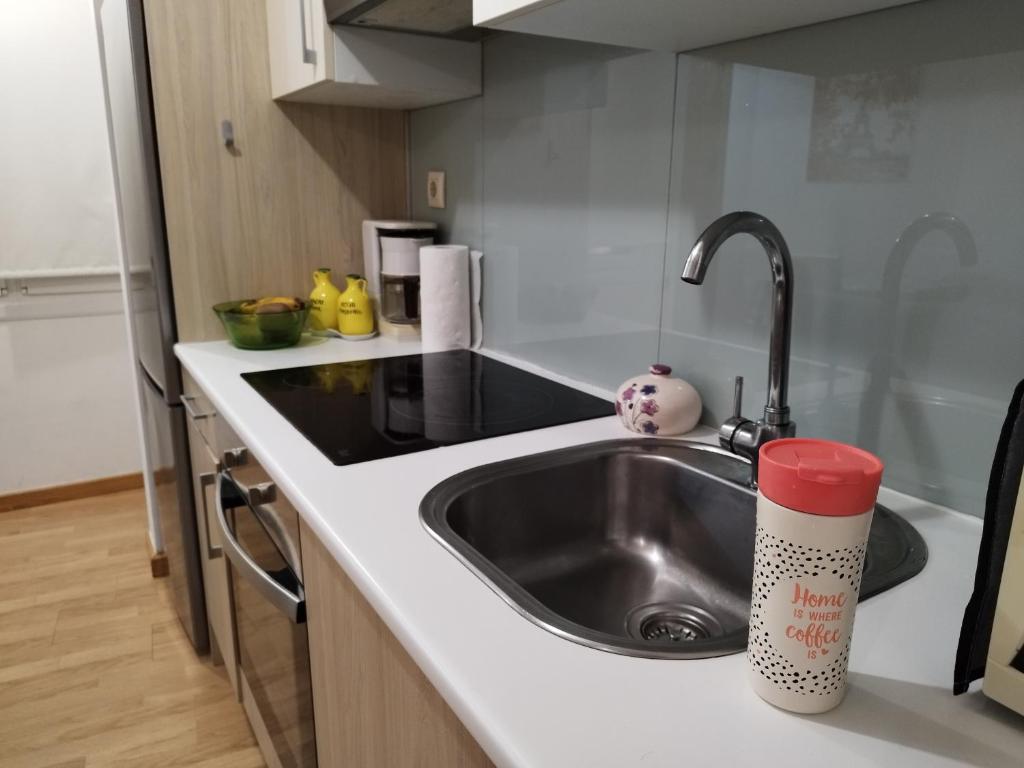 um lavatório de cozinha com uma caneca vermelha no balcão em Precioso Apartamento en Baiona Zona Centro em Baiona