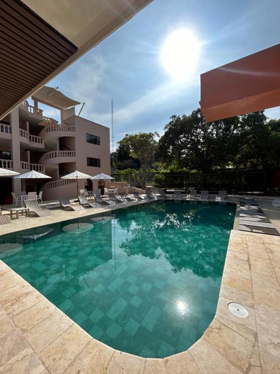 una piscina con sillas y un hotel en Del Trópico sopetrán en Sopetran