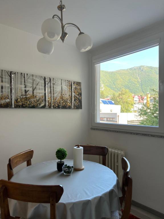 a dining room table with a white tablecloth and a window at Apartman “ Ismar “ in Travnik
