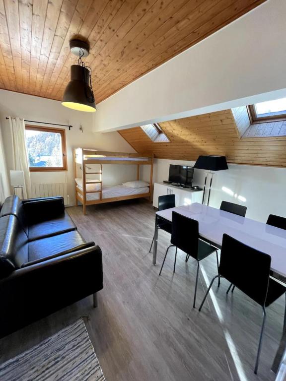 un salon avec un canapé, une table et des chaises dans l'établissement Chalet Saint-Patrick - Le Convivial, à Vars