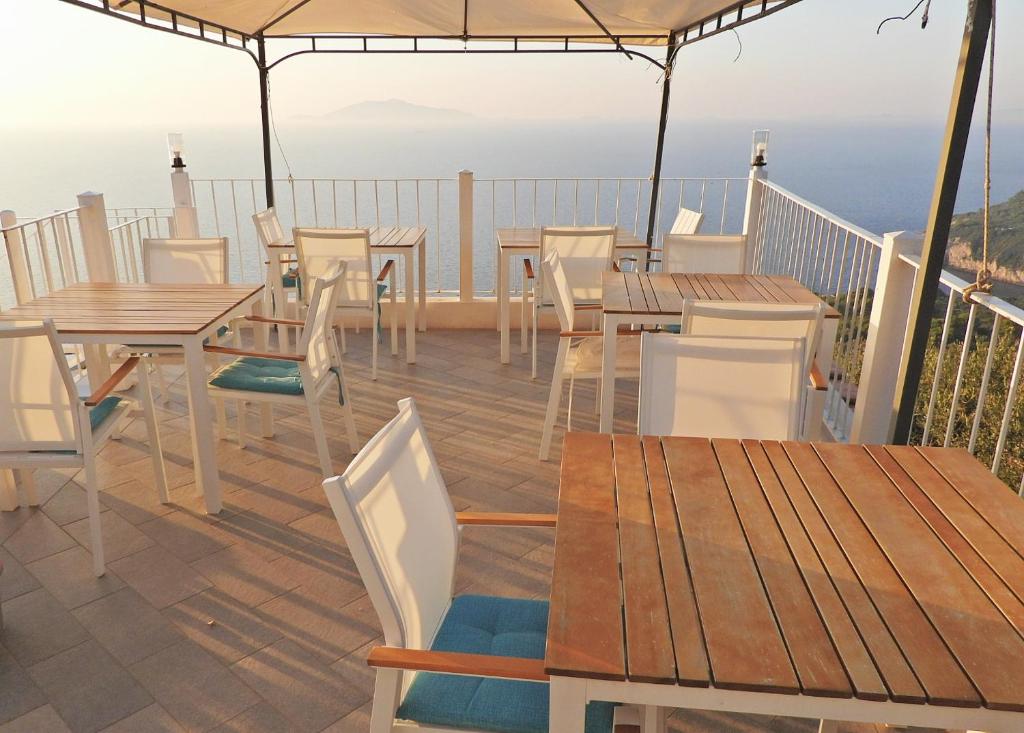 a deck with tables and chairs and a view of the ocean at B&B Il Paradiso di Capri in Anacapri