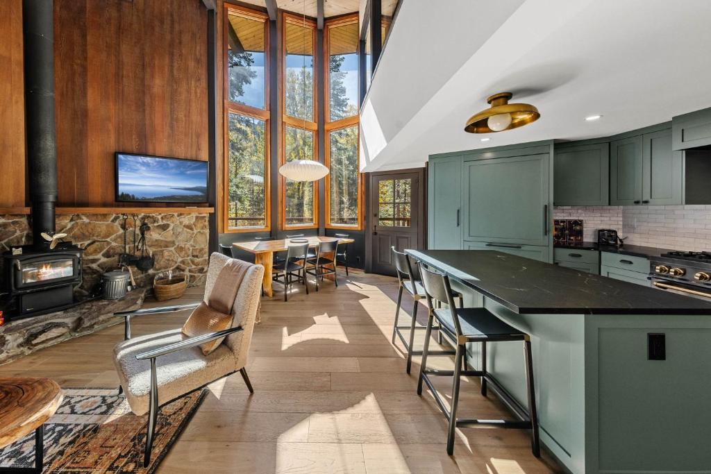a kitchen with green cabinets and a table and chairs at Birchwood Retreat by Tahoe Getaways - Newly Remodeled Pet Friendly Home in Alpine Meadows with Wood Fireplace, Hot Tub & Ski Shuttle! in Alpine Meadows