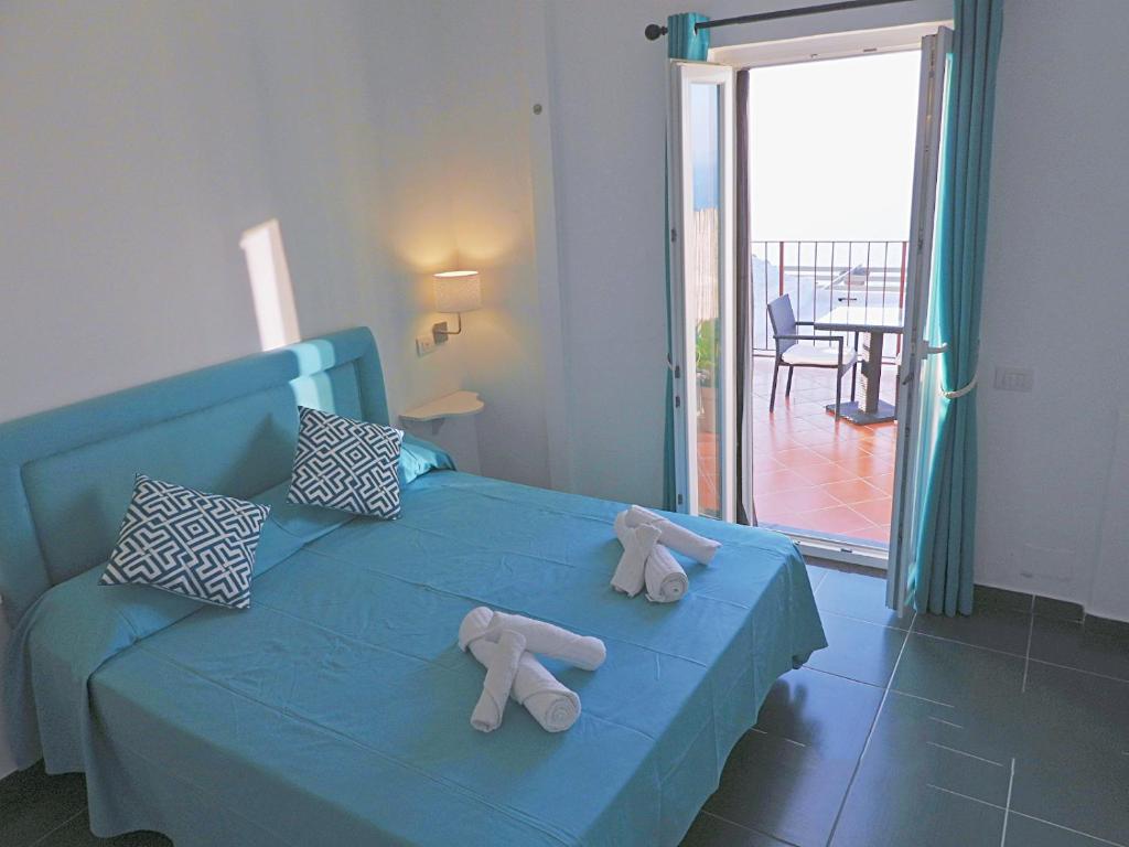 Una cama azul con dos animales de peluche. en B&B Il Paradiso di Capri, en Anacapri