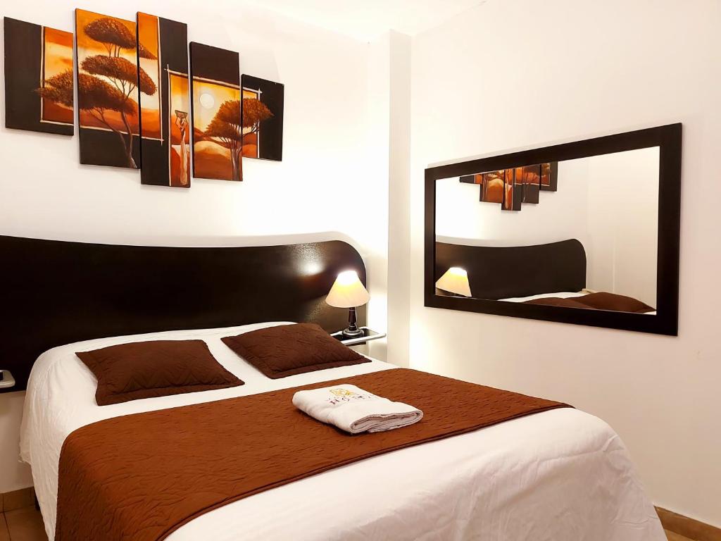 Un dormitorio con una cama grande y un espejo. en HOSTAL MURGEON BOUTIQUE, en Quito