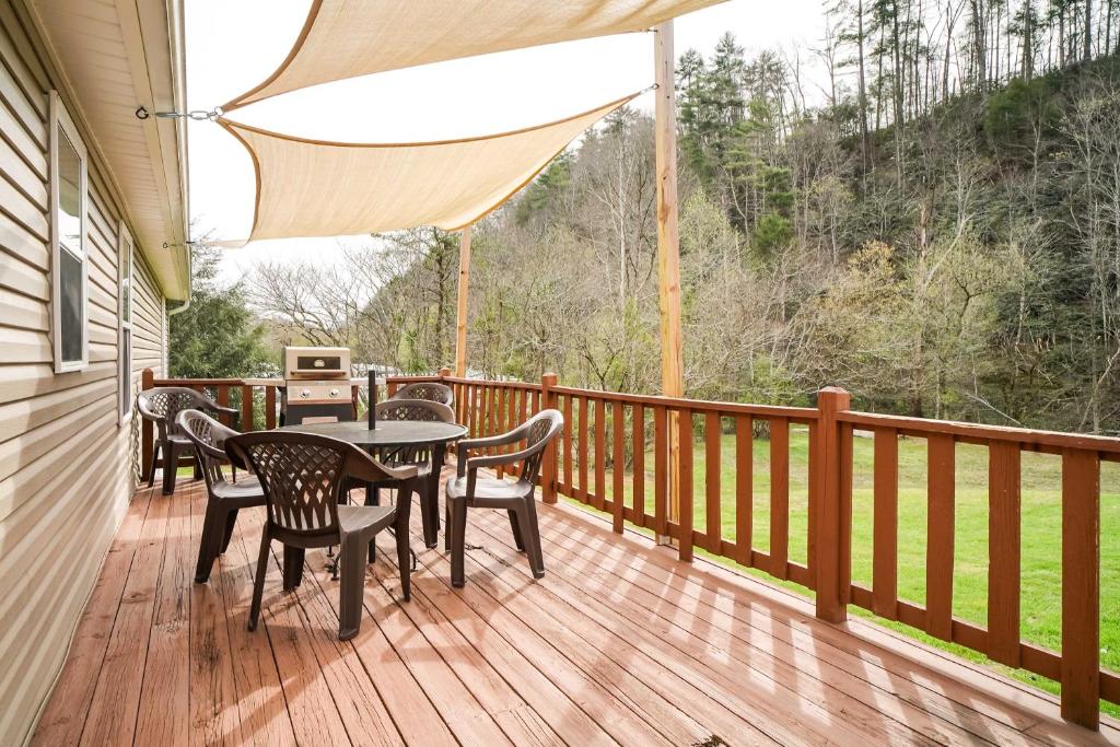 una terraza de madera con mesa y sillas. en Sevierville Home with Hot Tub about 4 Mi to Dollywood!, en Sevierville