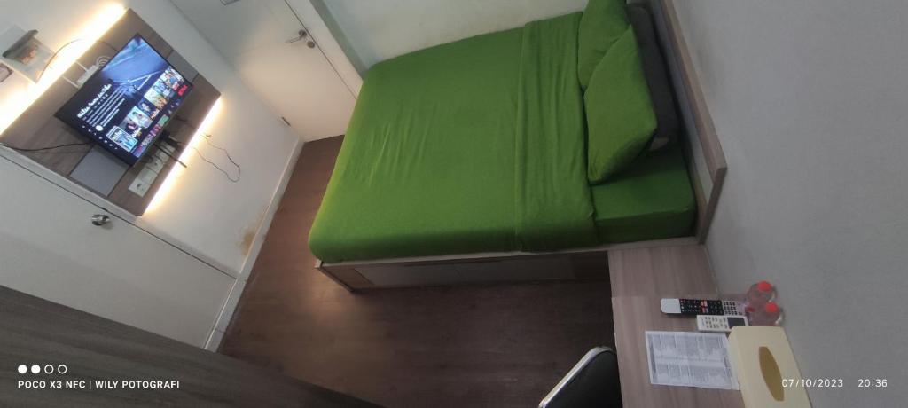 CITRA INN في Teko: أريكة خضراء في غرفة مع نافذة